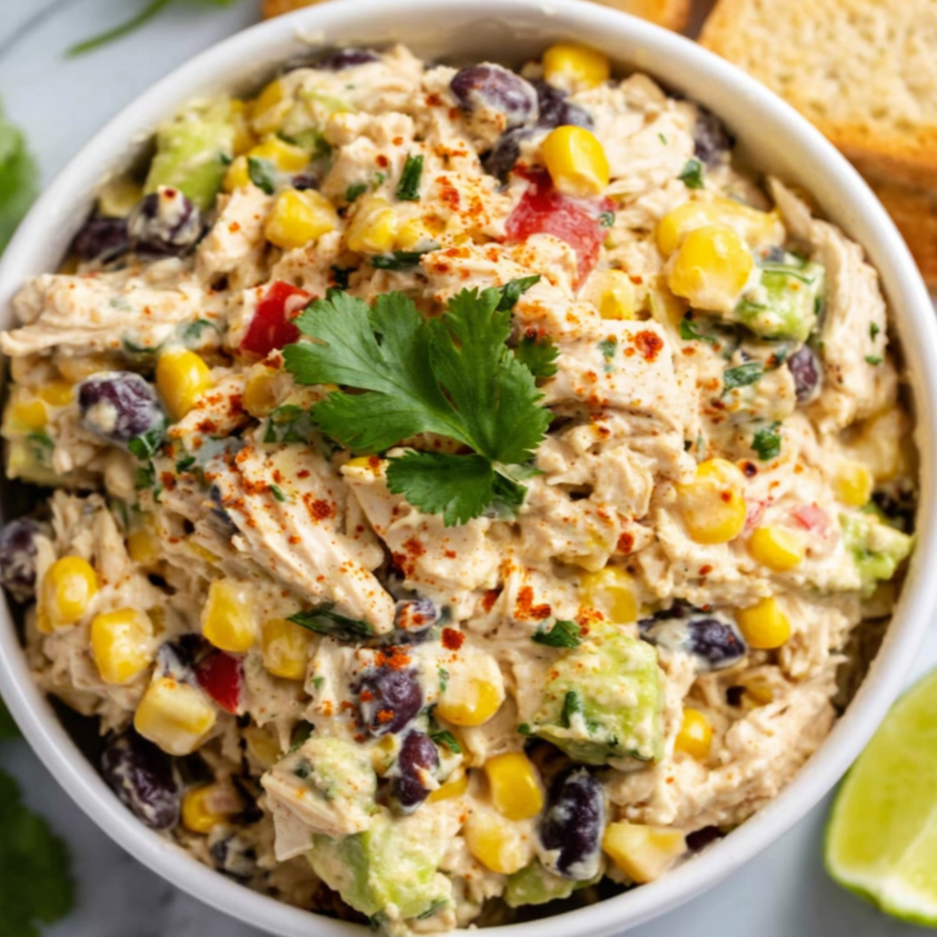 High Protein Southwest Chicken Salad (Macro-Friendly & Meal Prep Ready!) 3 Creamy high protein Southwest chicken salad with shredded chicken, black beans, corn, avocado, and cilantro served in a white bowl on a gray marble background