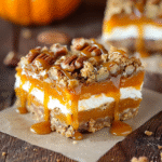 Close-up of caramel apple cheesecake bars with pumpkin swirl and pecans, drizzled with salted caramel